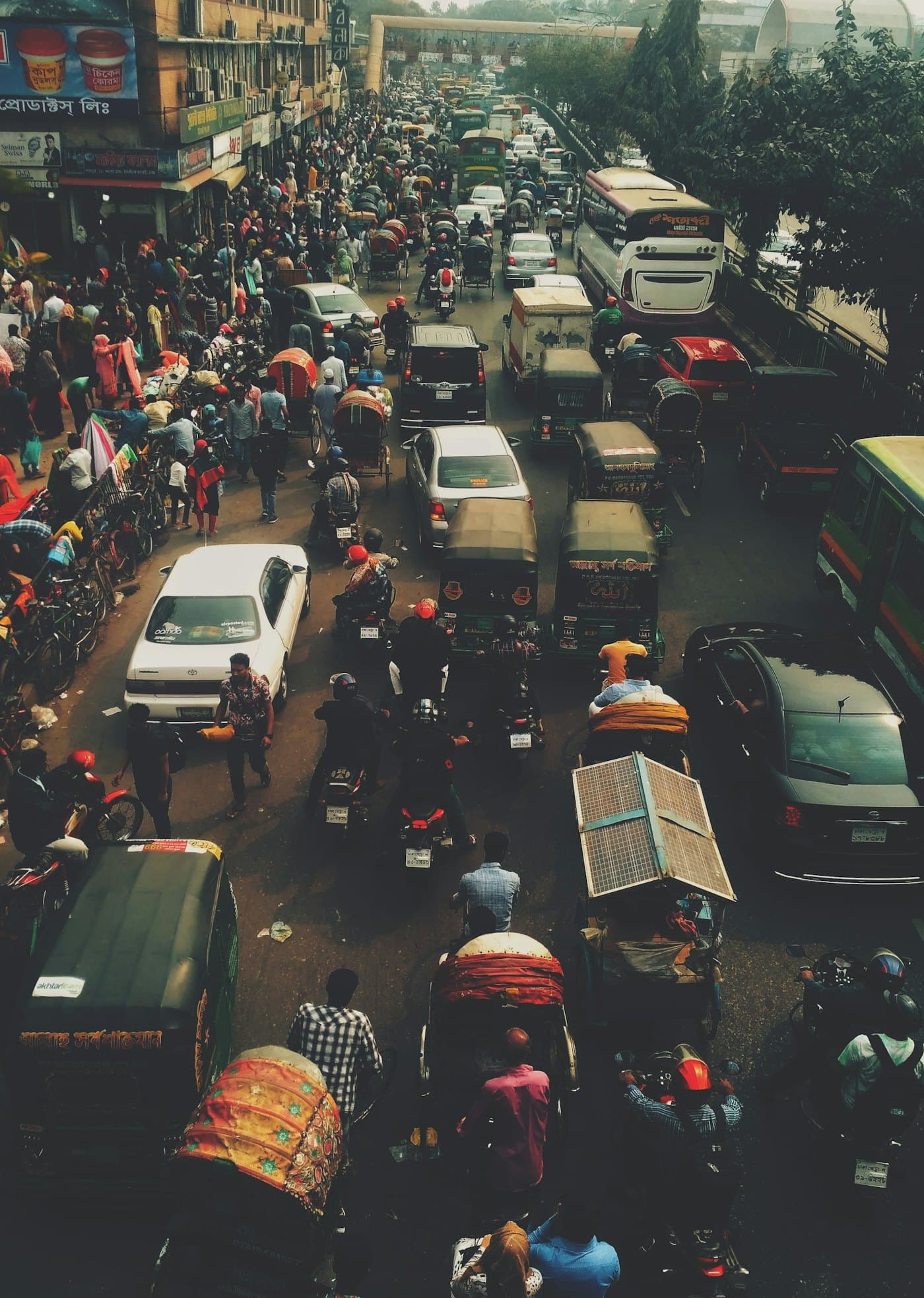 A crowded Dhaka street full of rickshaws, buses and people